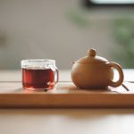 Chai Tea Cinnamon - clear glass cup with tea near brown ceramic teapot