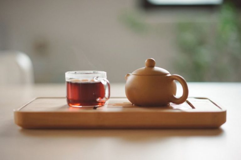 Chai Tea Cinnamon - clear glass cup with tea near brown ceramic teapot