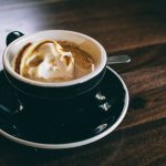 Gongdao Bei Cup - white and black ceramic mug filled with brown latte on round black ceramic saucer