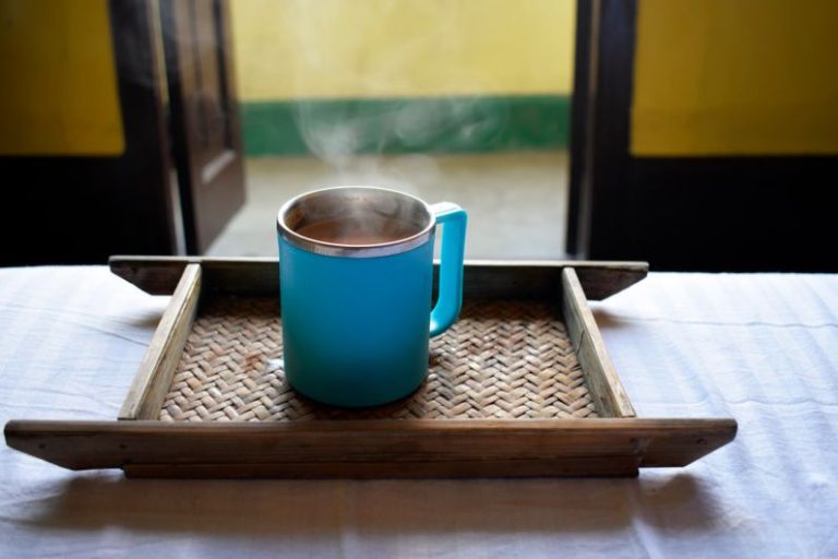 Bamboo Tea Tray - a blue cup on a wooden surface