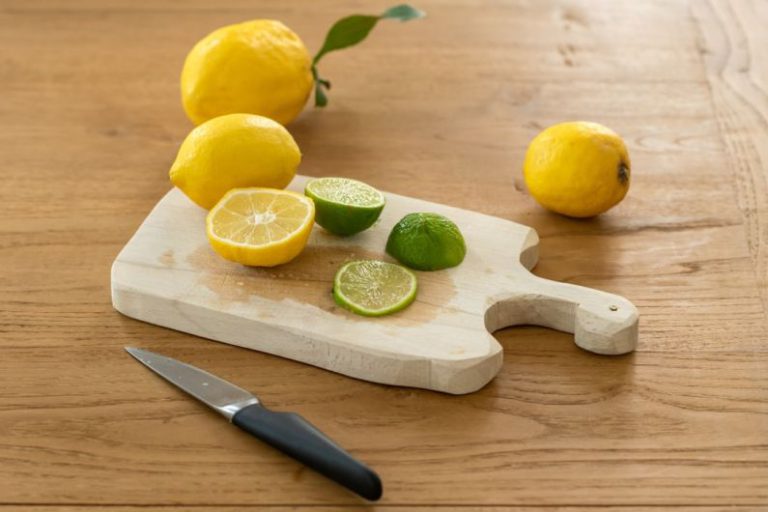 Lemon Balm Tea Lemon - sliced lemon beside knife on brown wooden chopping board