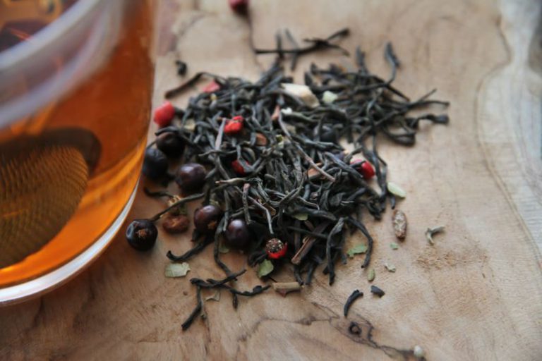 Tea Steeping Glass - red and black round fruit on brown wooden table