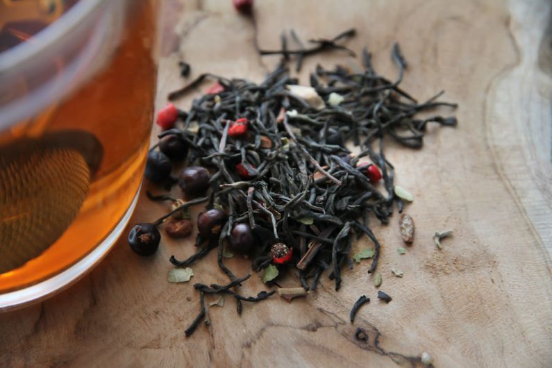 Tea Steeping Glass - red and black round fruit on brown wooden table
