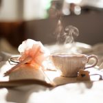 Sencha Tea Leaves - teacup on book beside pink flower decor