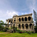 Philippines Tea Harvest - low-angle photography of brown concrete 2-storey building between trees