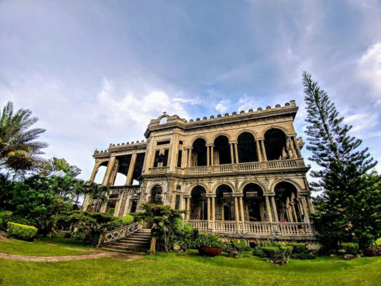 Philippines Tea Harvest - low-angle photography of brown concrete 2-storey building between trees