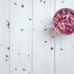 Jasmine Tea Petals - clear glass mug with cereal on white surface