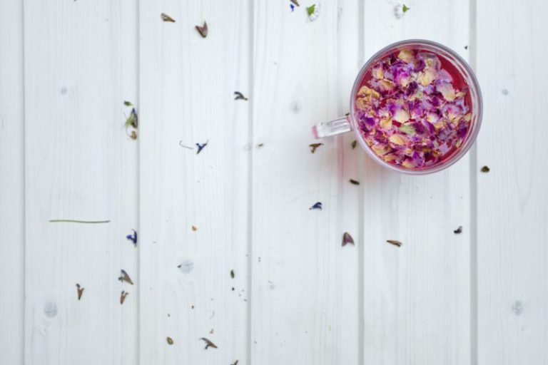 Jasmine Tea Petals - clear glass mug with cereal on white surface