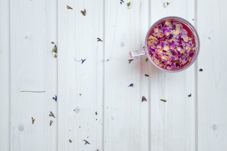 Jasmine Tea Petals - clear glass mug with cereal on white surface