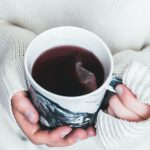 Milk Tea Bubble - person holding white and black cup with teabag inside