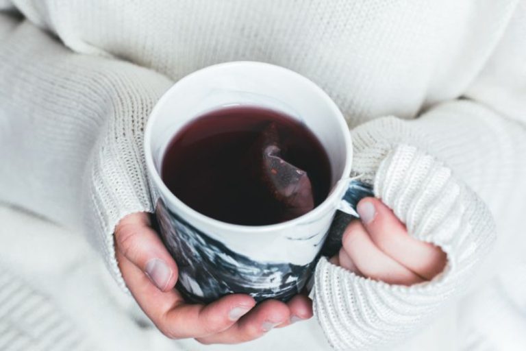 Milk Tea Bubble - person holding white and black cup with teabag inside