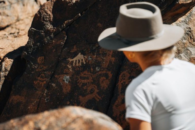 Tea History Scroll - a man wearing a hat standing next to a rock